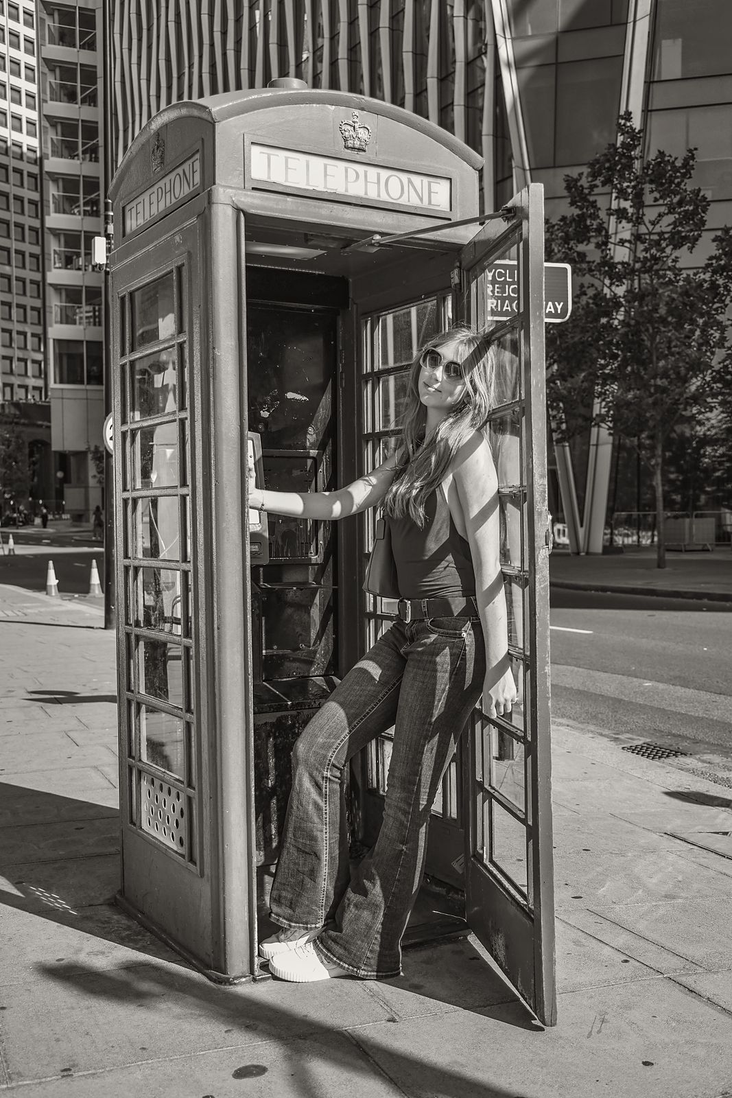 Leaning out of a telephone box door