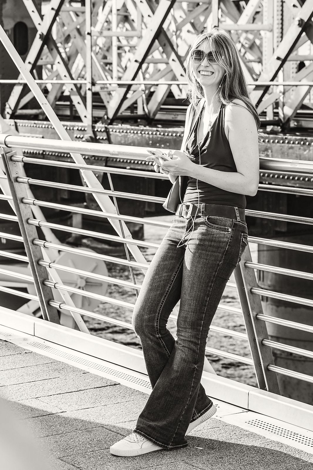 Full-length leaning on a steel bridge railing