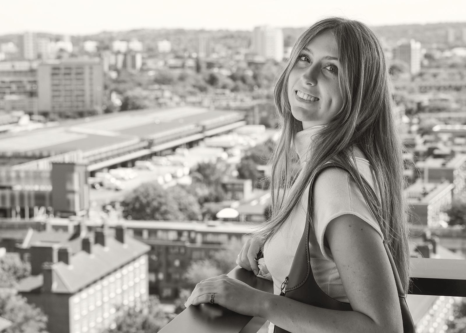 Smiling over her shoulder above a city skyline
