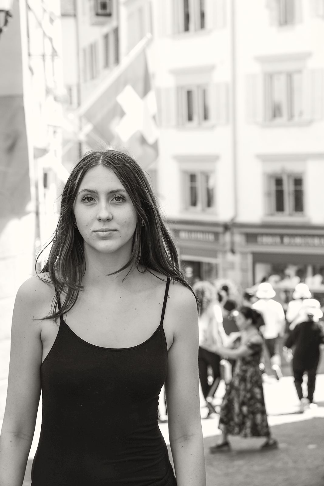 Three-quarter in a black slip dress on a city street