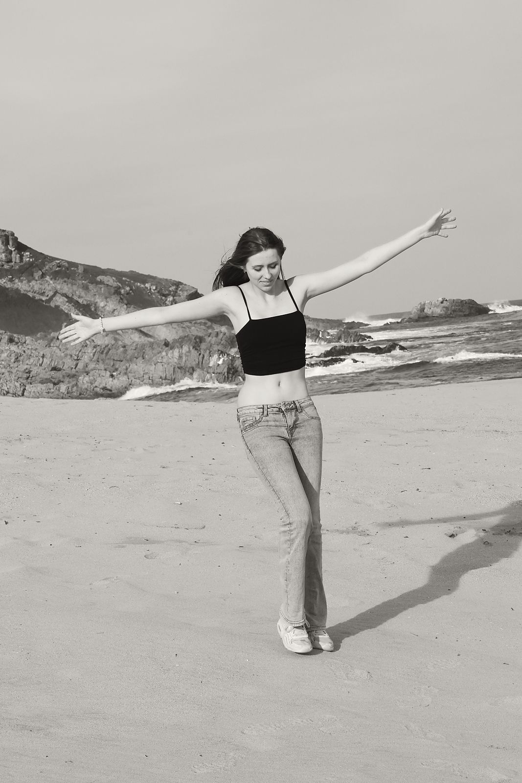 Full-length on a beach, arms outstretched